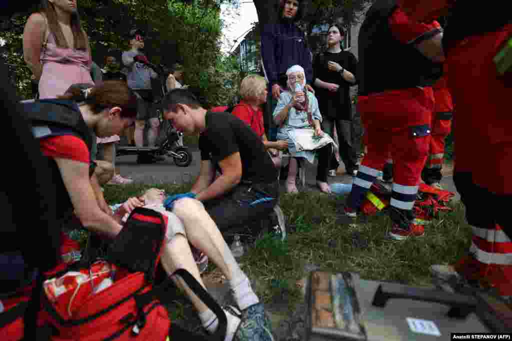 Медицинские работники оказывают помощь местным жителям, пострадавшим во время ракетного удара в Киеве, 8 июля 2024 года, фото AFP