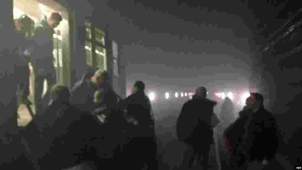 Пассажиры выходят из поезда метро в туннель между станциями Арс-Луа и Маельбек после взрыва на станции Маельбек в центре Брюсселя