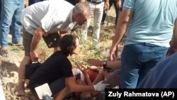 Люди оказывают помощь раненому велосипедисту